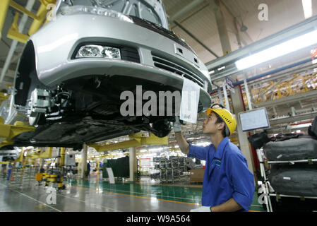 --FILE--A Chinese worker assembles a car on the assembly line at an ...