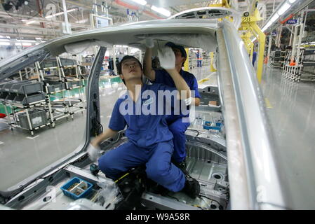 --FILE--Chinese workers assemble a car on the assembly line at the auto ...