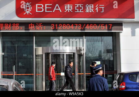 --FILE-- Local residents walk past a branch of Bank of East Asia (BEA) in Shenyang, northeast Chinas Liaoning province, January 26, 2010.   Bank of Ea Stock Photo