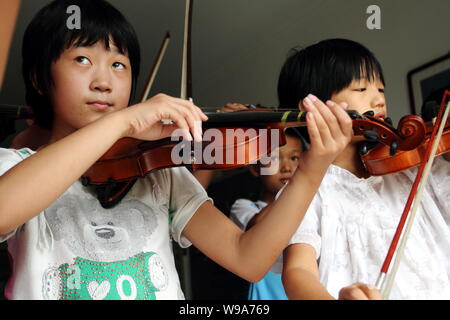Chinese kids learn playing violin in Donggaocun town, Pinggu District, Beijing, China, 12 August 2010.   Statistics shows that one third of worlds vio Stock Photo