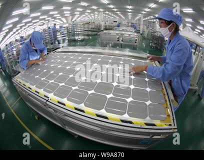 --FILE-- Chinese factory workers manufacture solar power panels at a plant in Nantong, east Chinas Jiangsu province, January 5, 2010.    The focus of