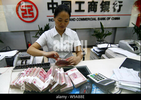 --FILE--A Chinese clerk counts RMB (renminbi) yuan banknotes at a branch of ICBC (Industrial and Commerical Bank of China) in Fuyang city, east Chinas Stock Photo