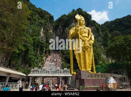 The giant, gold statue of Lord Murugan dominates the stairway entrance to Batu Caves in Kuala Lumpur, Malaysia Stock Photo