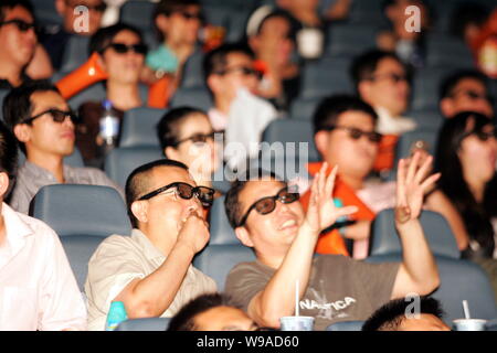 Chinese football fans wearing 3D glasses watch the 3D broadcast of a football match of the 2010 World Cup between Netherlands and Slovakia at a cinema Stock Photo