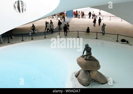 Visitors look at the Little Mermaid inside the Denmark