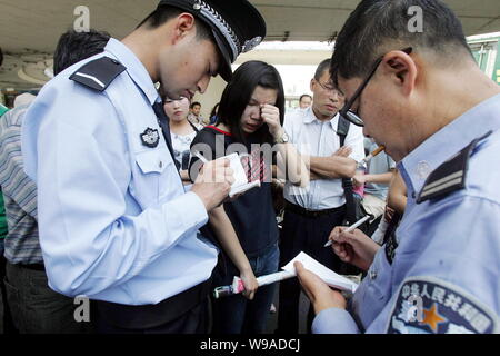 Chinese police officers question the student whose mobile phone is said to have been stolen by two thief suspects holding babies in Zhengzhou city, ce Stock Photo