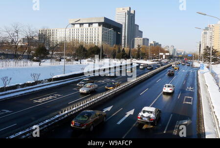 Cars drive on a street after heavy snow falls were cleared away in Beijing, China, Monday, 4 January 2010.   Beijing saw smooth flow of traffic Monday Stock Photo