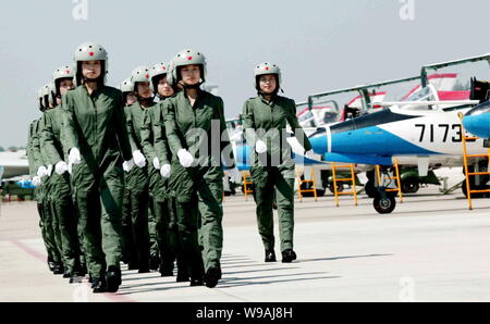 --FILE--Young female Chinese fighter jet pilots of Chinese PLA Air Force walk past training planes at an airport in Beijing, China, 30 August 2009. Stock Photo
