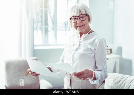 Elegant fashionable retired woman wearing glasses feeling extremely happy Stock Photo