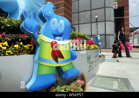 Local Chinese residents walk past Haibao figures, the official mascot of the World Expo 2010, in Shanghai, China, 17 April 2010.   The promotion song Stock Photo