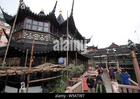 Chinese tourists walk on the Bridge of Nine Turnings (Jiuqu Bridge) in front of the renovated Huxingting Teahouse in the Yu Garden in Shanghai, China, Stock Photo