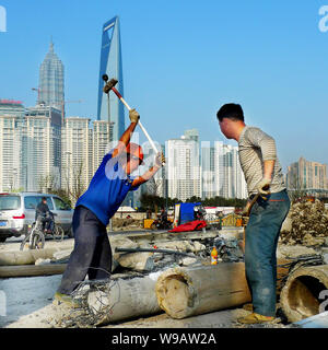 --FILE--Chinese migrant workers labor at a construction site near the Bund against the skyline of Pudongs Lujiazui Financial District in Shanghai, Chi Stock Photo