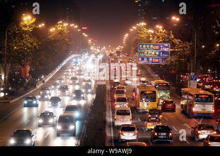 --FILE--Night view of buses and cars moving slowly during a traffic jam on a road in Beijing, China, 27 October 2010.   The State Council has approved Stock Photo