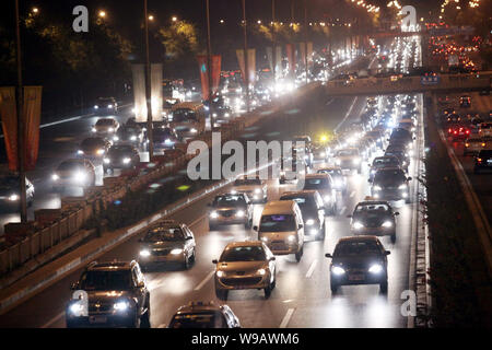 --FILE--Night view of buses and cars moving slowly during a traffic jam on a road in Beijing, China, 27 October 2010.   The State Council has approved Stock Photo
