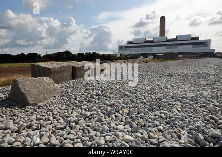 The huge building housing Aberthaw coal fired power station in the background with a long line of anti tank defences from the wartime defences. Stock Photo