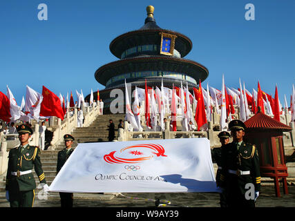 Chinese paramilitary policemen hold the flag of the Olympic Council of Asia during the torch lighting ceremony of the 2010 Guangzhou Asian Game in fro Stock Photo