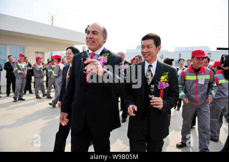 Muhtar Kent, center, Chairman and CEO of The Coca-Cola Company, toasts with a bottle of cola during the opening ceremony of the bottling plant of Swir Stock Photo