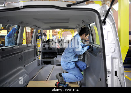 --FILE--Chinese factory workers assemble a Mercedes-Benz van on the assembly line in the auto plant of Fujian Daimler Automotive Co., Ltd. in Fuzhou c Stock Photo