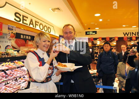 Trond Giske, second left, Minister of Trade and Industry of Norway, poses with a Norwegian woman to promote salmon from Norway during his visit to a s Stock Photo