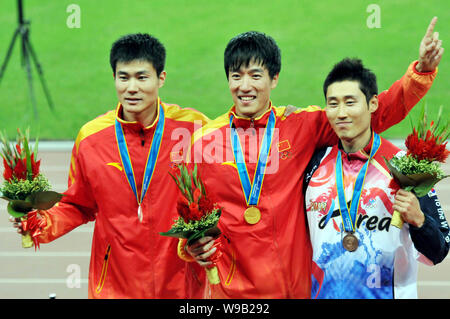 (From left) Silver medalist Shi Dongpeng of China, gold medalist Liu Xiang of China and bronze medalist Park Taekyong of South Korea pose on the podiu Stock Photo