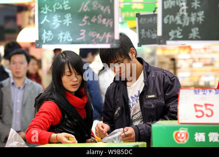 Chinese customers shop for fruits at a supermarket in Jiujiang city, east Chinas Jiangxi province, 3 December 2010.   Chinas government said it will r Stock Photo