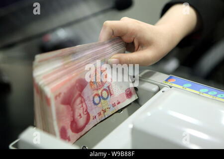 --FILE--A Chinese bank clerk counts RMB (renminbi) yuna banknotes at the headquarters of HSBC China in the Lujiazui Financial District in Pudong, Shan Stock Photo