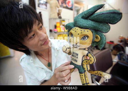 Chinese hairstylist Huang Xin shows his hair-made Zakumi, the official mascot of the World Cup South Africa 2010, in a hair salon in Beijing, China, 1 Stock Photo