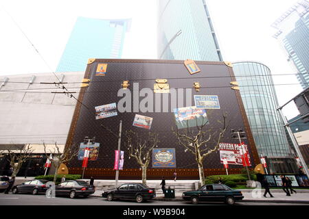 A Chinese woman walks past a huge Louis Vuitton (LV) suitcase displayed  outside the Plaza 66 shopping mall in Shanghai, China, 21 April 2010. In  May Stock Photo - Alamy