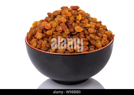golden yellow raisins in a black and orange bowl Stock Photo