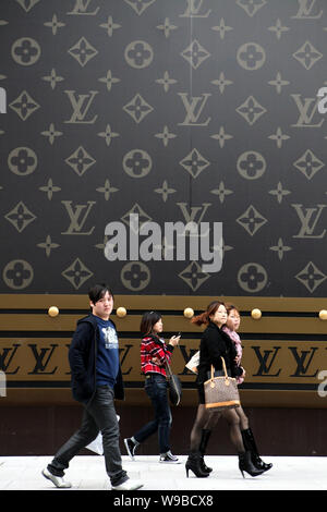 Una atractiva mujer joven llevando un Louis Vuitton (LV) Bolso camina  delante de una enorme maleta LV fuera del centro comercial Plaza 66 en  Shanghai, China, 4 de Nove Fotografía de stock - Alamy