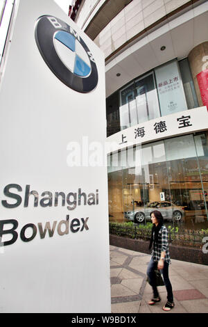 A Chinese woman walks past a BMW dealership in Shanghai, China, 11 October 2010.   German auto giant BMW Group on Friday (15 October 2010) began recal Stock Photo