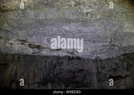 Abstract stone background. Rock formations on the arches and walls of the hall in the cave. archeology. Grey grunge textured. Stock Photo