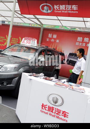 --FILE--A Chinese salesman looks at a Hover H3 SUV of Great Wall Motors during an auto show in Yichang city, central Chinas Hubei province, 7 October Stock Photo