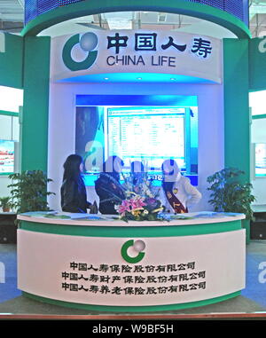 --File-- Chinese staff are seen at a stand of China Life Insurance Company Ltd. during an exhibition in Changsha, central Chinas Hunan Province, Decem Stock Photo