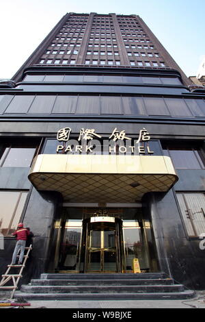 A Chinese worker puts final touches on the Park Hotel after a face-lift in Shanghai, China, 6 January 2010.   The Park Hotel, the highest building in Stock Photo