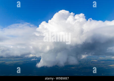 Closeup of one single big white cloud on the right side, in the clear deep blue sky, on a sunny day. Stock Photo