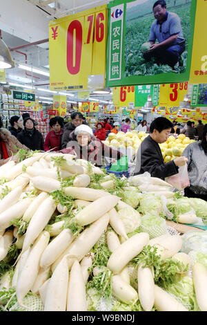 Chinese customers shop for radishes and other vegetables and fruits at a supermarket in Beijing, China, 11 December 2010.   China risks a more abrupt Stock Photo