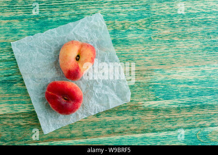 chinese flat peaches on rustic colorful background with copy space. Flat lay background. Stock Photo
