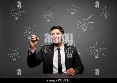 Businessman making light bulbs Stock Photo