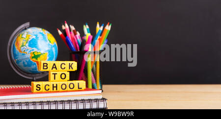 World globe and stationery with text in front of chalkboard Stock Photo