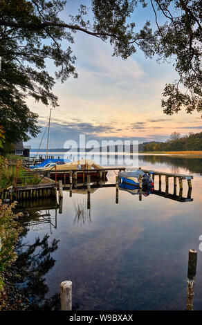 Pier with boats and cottages at Schwerin lake at dusk. Stock Photo