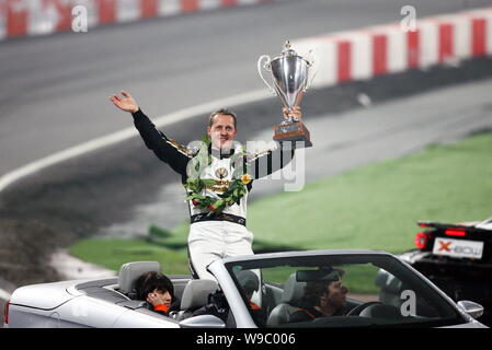 Seven-time Formula One world champion Michael Schumacher holding his trophy waves to the audience after the Race of Champions (ROC) at the National St