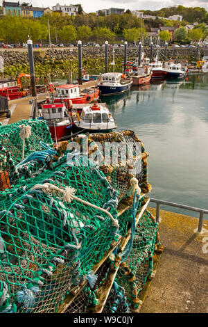 Ireland, Leinster, Fingal, Co Dublin, Howth, lobster pots on quay at working fishing boats moored in harbour Stock Photo