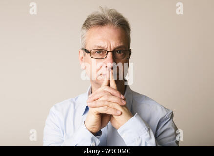 Senior man in glasses thinking over background Stock Photo