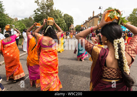 Women carrying milk pots on their head, known as“paal kudam, during the Tamil Chariot Festival, an annual Hindu festivity, in West Ealing. London Stock Photo
