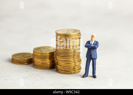 Successful businessman with big profits at the top of the stairs by coins. Adequate investment in the company Stock Photo