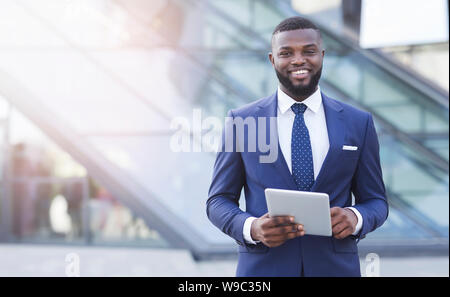 Cheerful African American Businessman Holding Digital Tablet In Urban Area Stock Photo