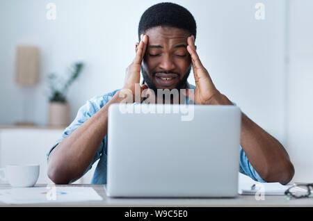 Tired businessman having headache at office, feeling sick Stock Photo