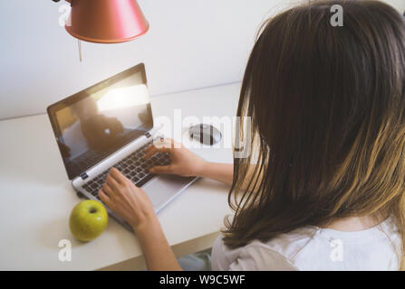 Woman working on a computer in a hotel. Rear view. Stock Photo