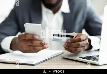 Serious businessman paying his bills online using application in smartphone Stock Photo